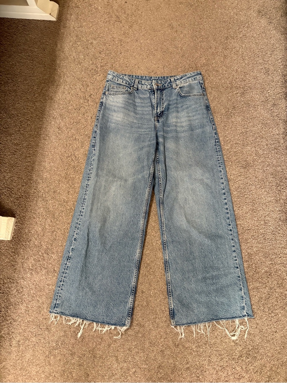 Divided wide legged distressed hem jeans